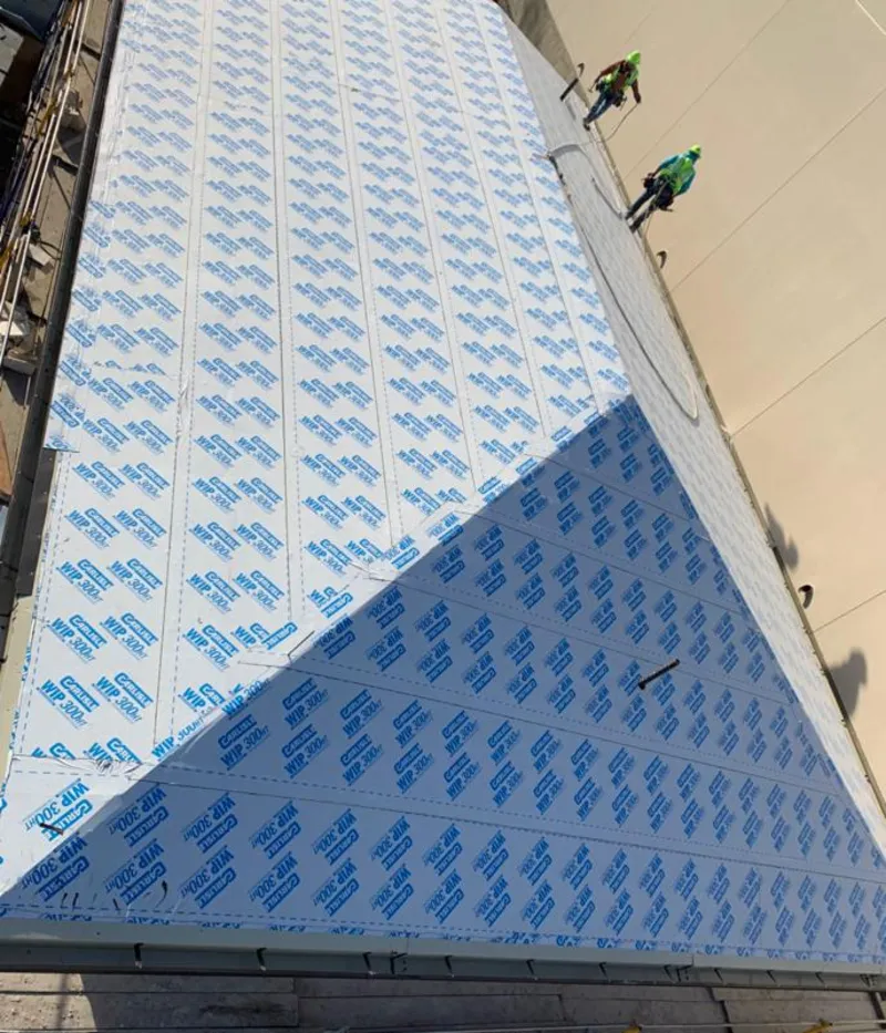 Professional roofers installing underlayment on a metal roof in Kingston